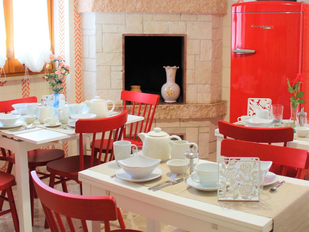图列La Chiave Rossa B&B的一间带桌子和红色椅子的用餐室以及壁炉