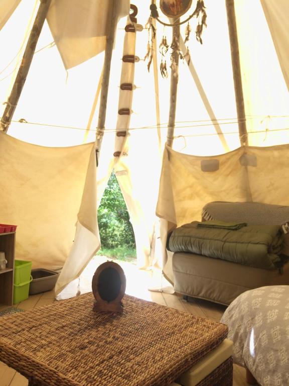 加瓦尔尼Tipis nature的帐篷内带一张床和一张桌子的房间