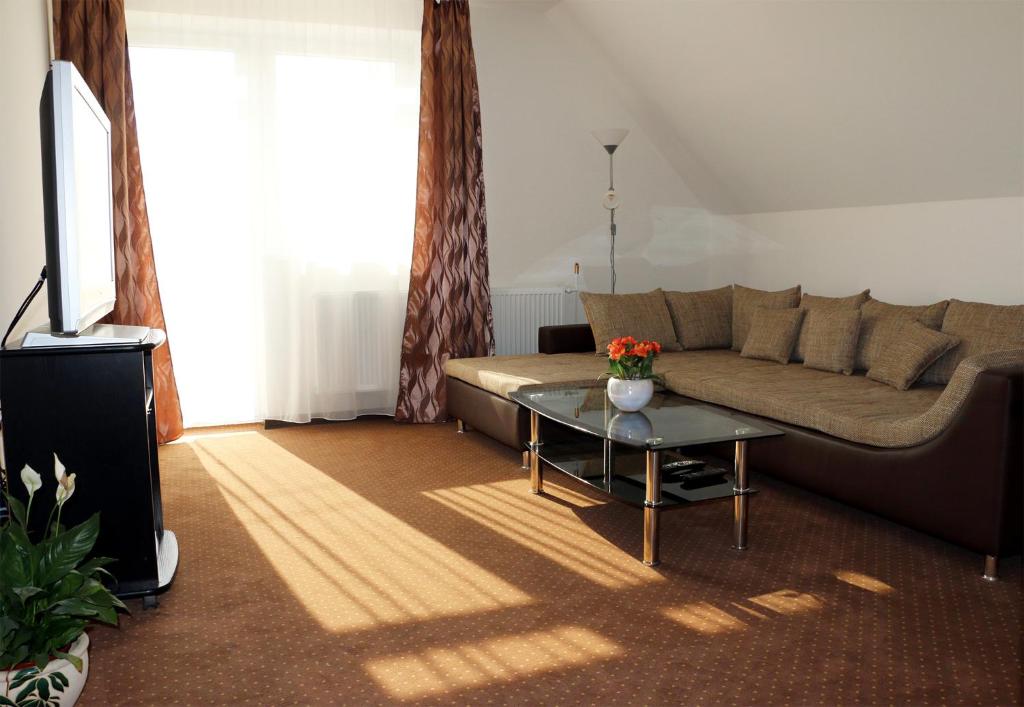 PusztavámSeSil Apartman的客厅配有沙发和桌子