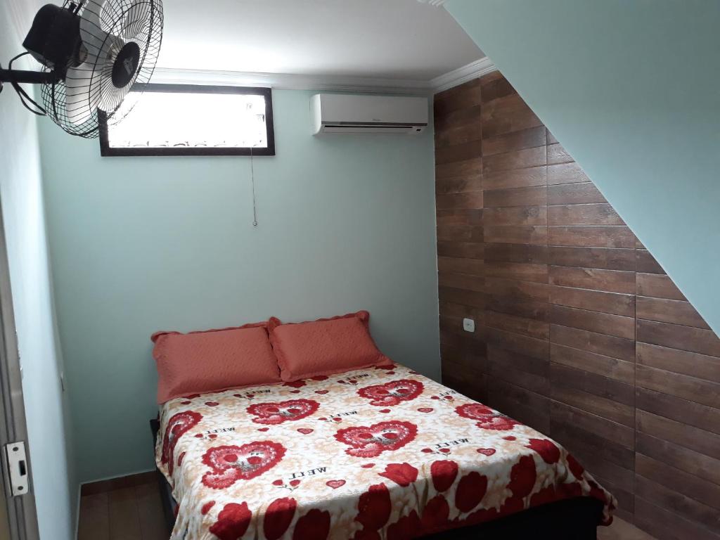 欧纳波利斯Casa de amigos e parentes的一间卧室配有一张带红色和白色棉被的床
