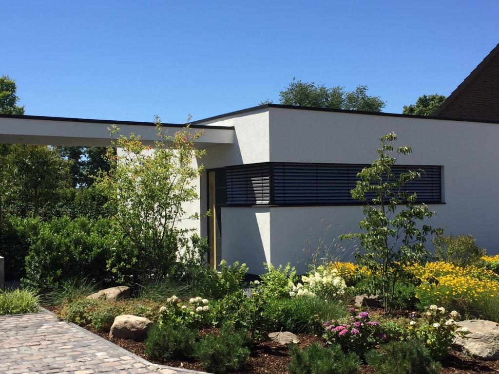 克拉嫩堡das Ferienhaus Auszeit的白色的房子,设有黑窗和花园