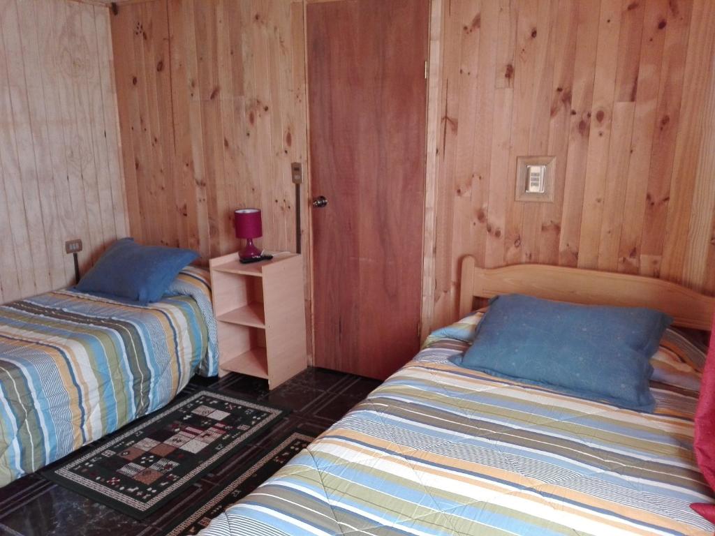 安库德Hospedaje Los Calafates的木墙客房的两张床