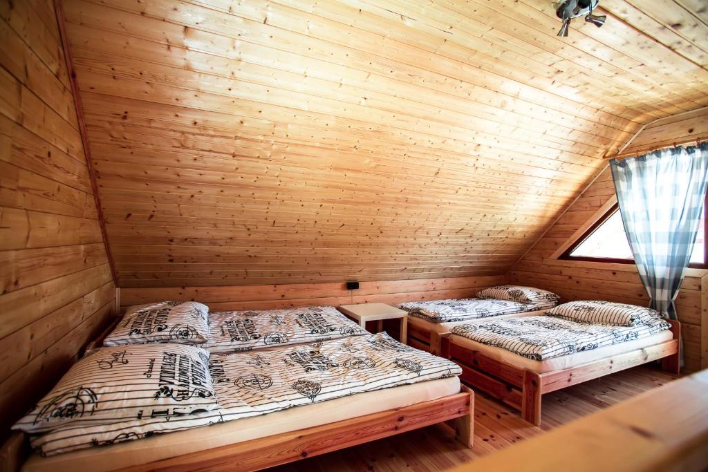 尤斯托尼莫斯基Domki Heaven Ustronie Morskie的小木屋内的两张床,设有窗户