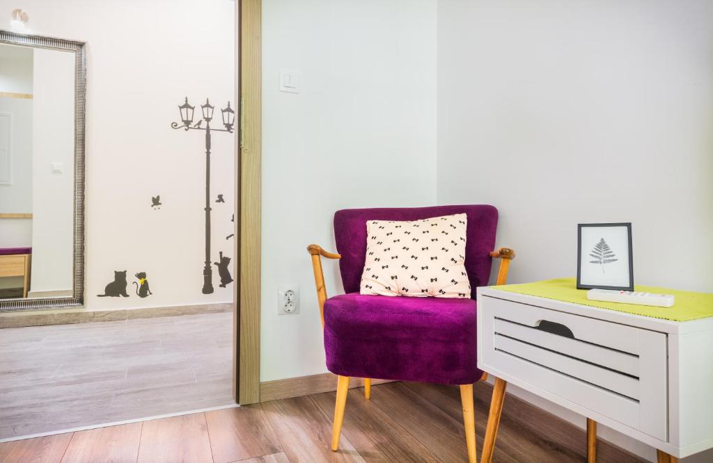 斯普利特Apartman Nicoletta的梳妆台和镜子旁的紫色椅子