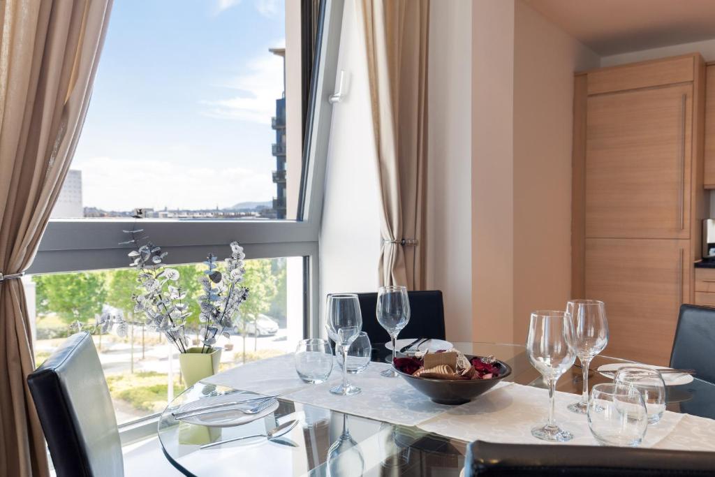爱丁堡Stylish Garden View Apartment的用餐室配有带酒杯的桌子和窗户