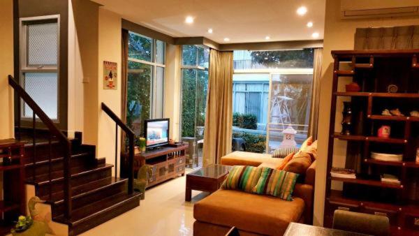 七岩华欣泰迪熊别墅的带沙发、电视和窗户的客厅