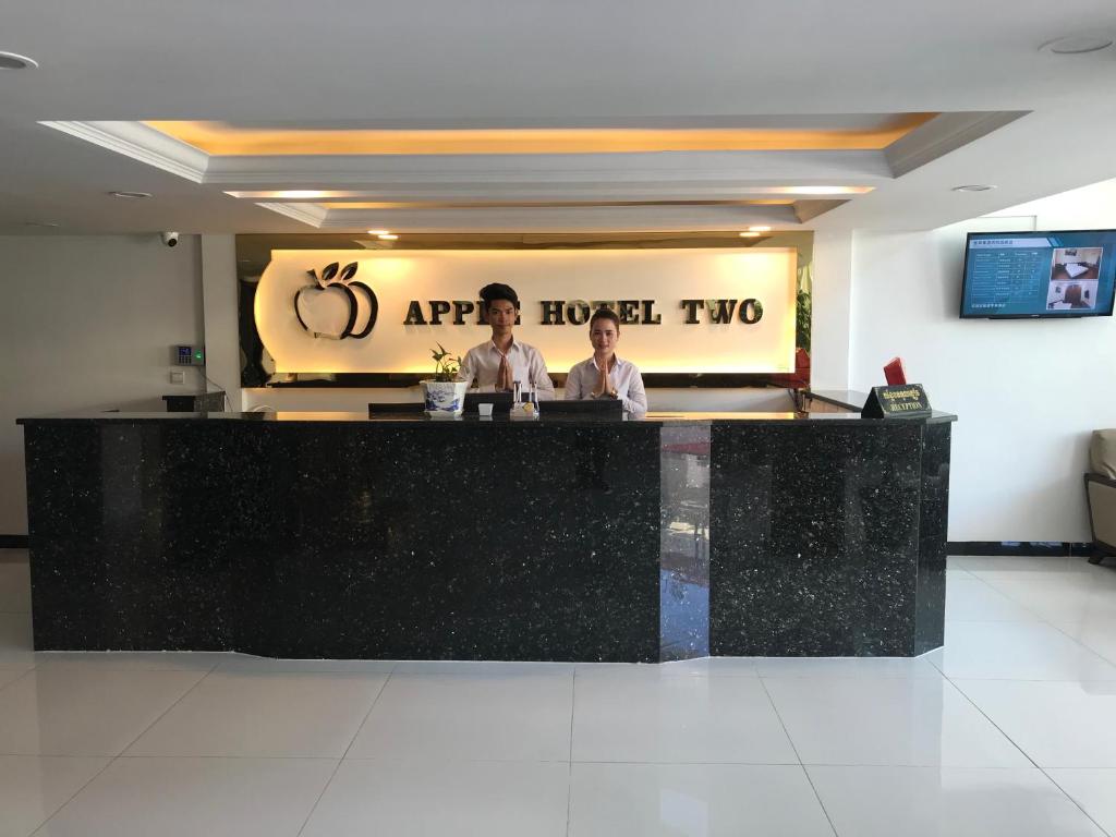 金边Apple Hotel Two - Near Phnom Penh Airport的两人站在餐厅柜台