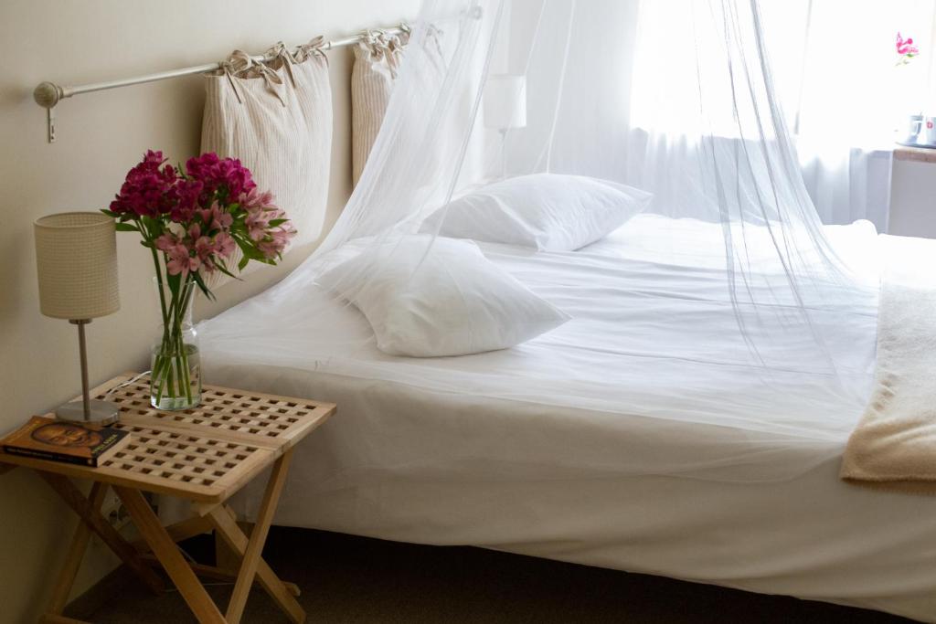 库雷萨雷库尔萨宾馆的一张白色的床,桌子上放着花瓶
