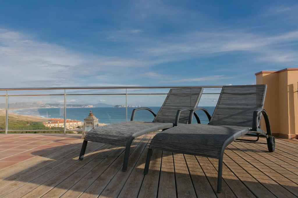 巴古尔2 bedroom apartment in Sa Punta, Begur- Sea views, terrace, pool and access to the beach (Ref:H29)的一张椅子坐在甲板上,俯瞰大海