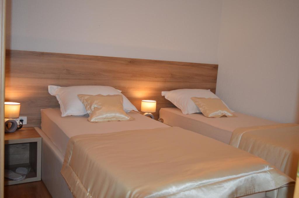 GrabovicaBlue Lake Luxury Rooms的配有2盏灯的酒店客房的2张床