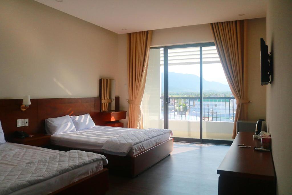金兰My Ca Hotel的酒店客房设有两张床和一个阳台。