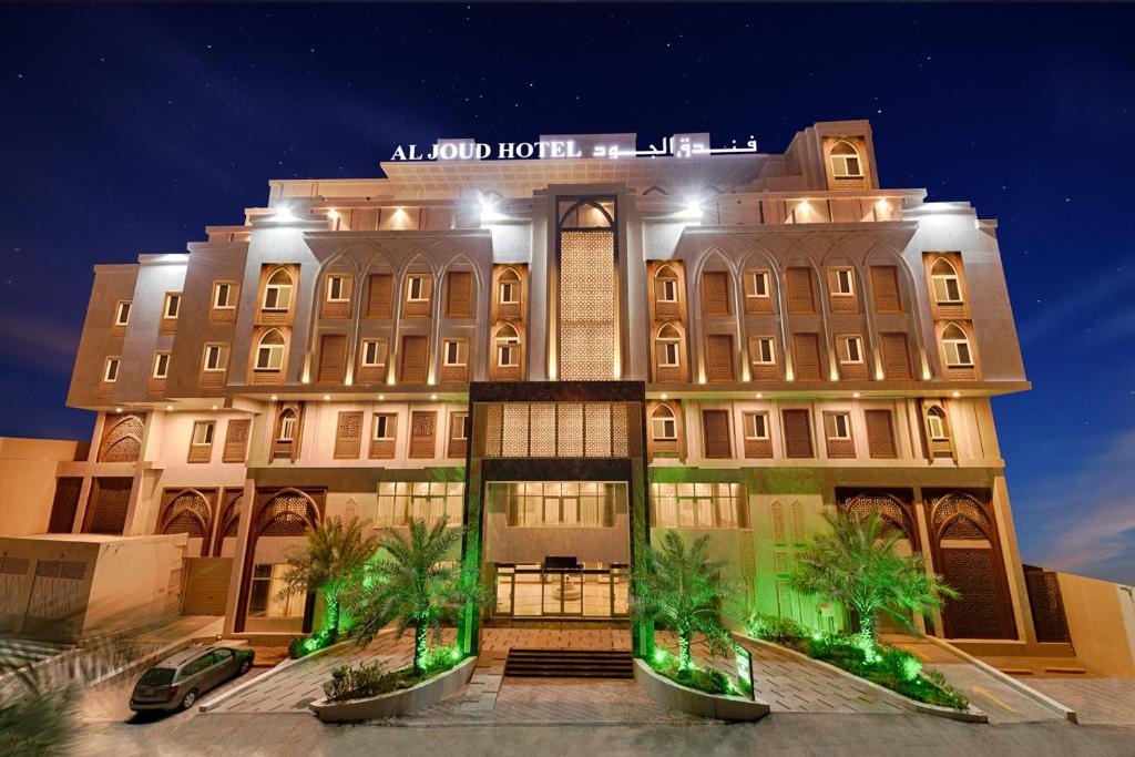 麦加Al Joud Boutique Hotel, Makkah的一座棕榈树环绕的大建筑
