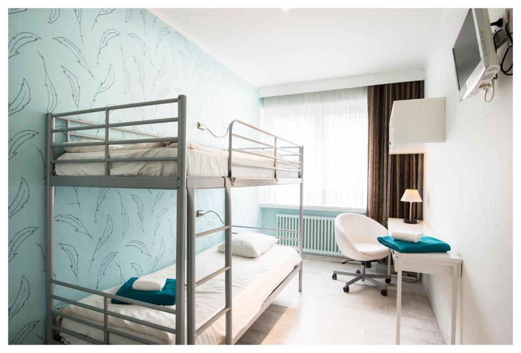 奥斯坦德特尔斯特里普酒店的一间卧室配有两张双层床和一张书桌