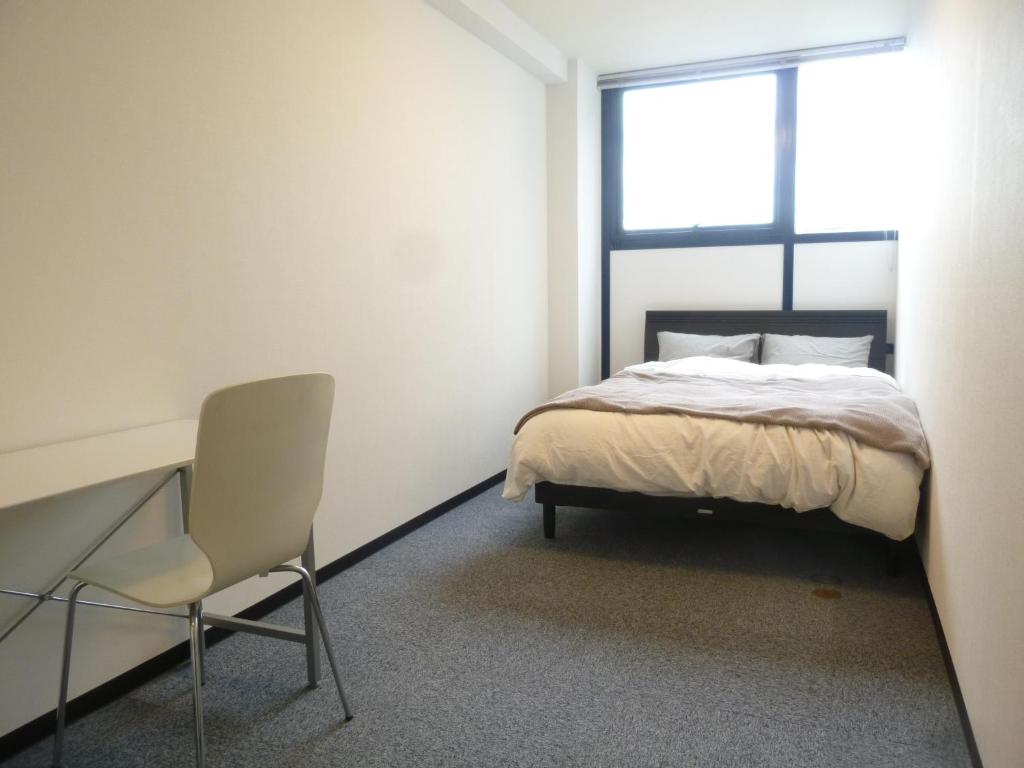 名古屋Nagoya Motoyama House D的一间卧室配有一张床和一把椅子