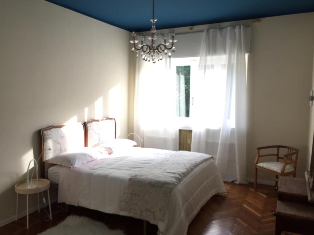 奥斯塔Beaucoeur的一间卧室配有一张带吊灯和窗户的床。