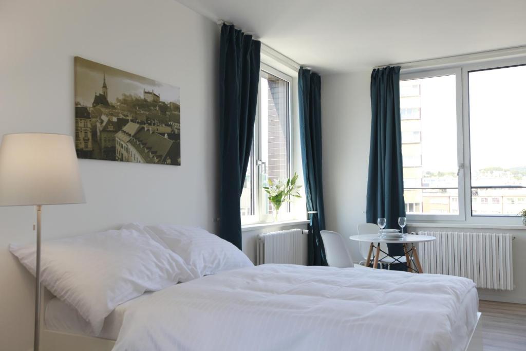布拉迪斯拉发City Center Best Place Apartments的白色的卧室设有白色的床和窗户。