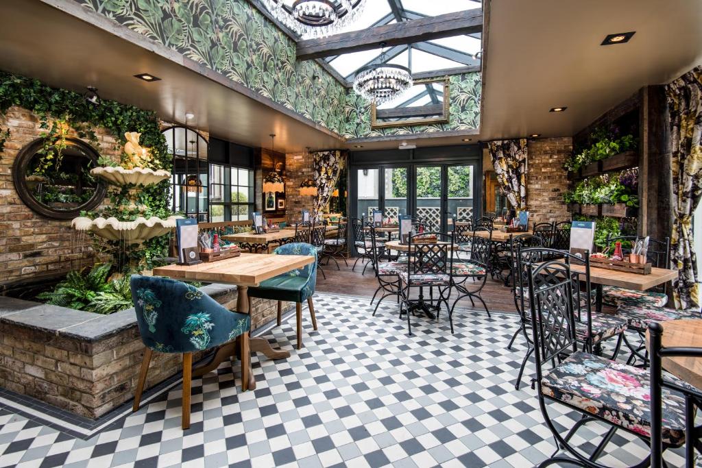 锡厄姆The Seaton Lane Inn - The Inn Collection Group的一间带桌椅和天花板的餐厅
