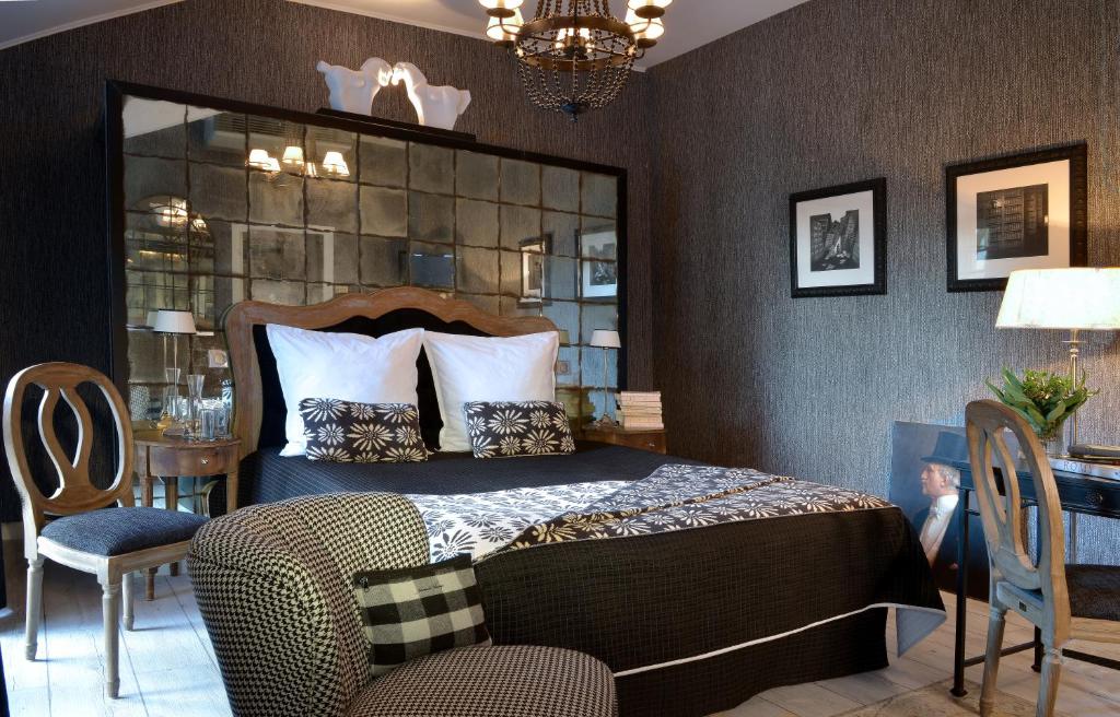 索米尔圣皮埃尔酒店的一间卧室配有一张大床和一张桌子及椅子