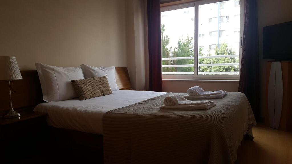 里斯本Lisbon Location的酒店客房,配有带两条毛巾的床