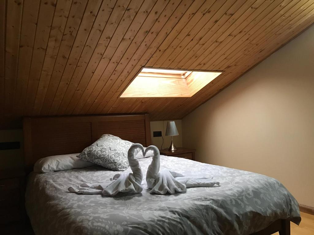 塞拉内华达Apartamentos Vista Sierra Nevada的卧室的床上有两只白天鹅