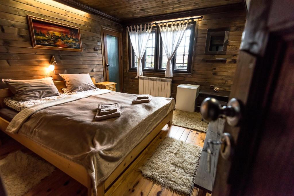 班斯科Banskovilla Zlateva House的卧室配有一张床铺,位于带木墙的房间内