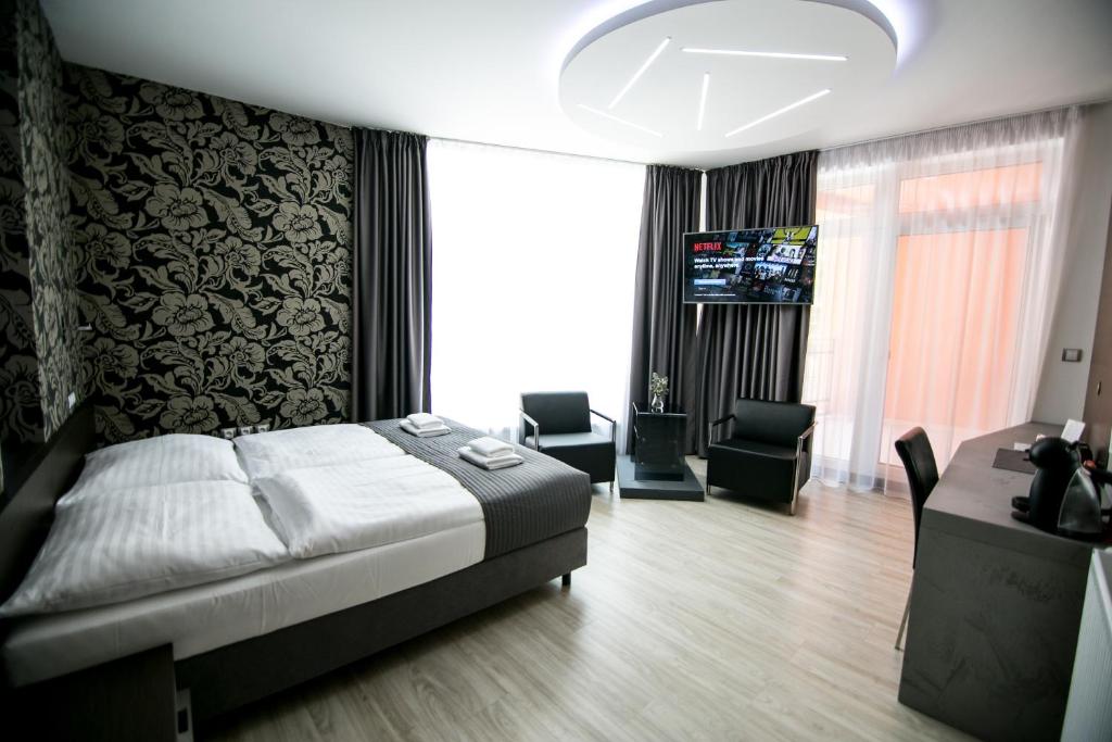 莫德日采Hotel U Kostela的一间卧室配有一张床、一张书桌和一台电视