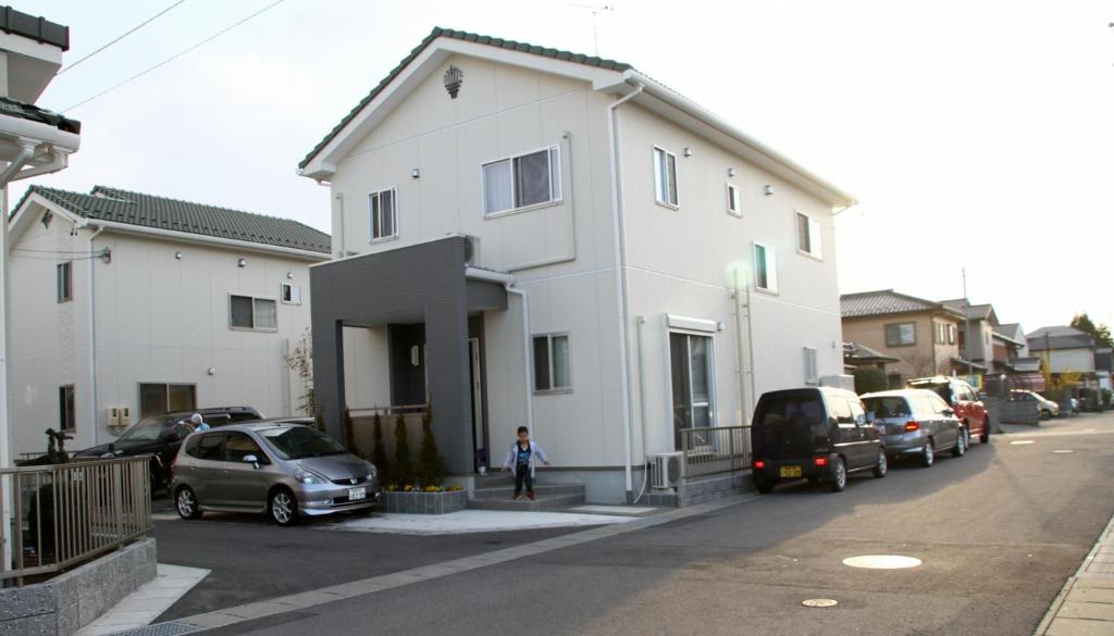 垂井町波萨达卡萨生态酒店的停车场内有汽车停放的白色房子