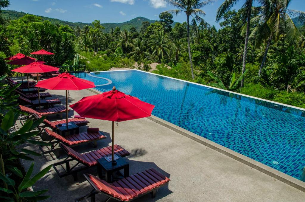 湄南海滩Kirikayan Residences Koh Samui的毗邻度假酒店的带椅子和遮阳伞的游泳池
