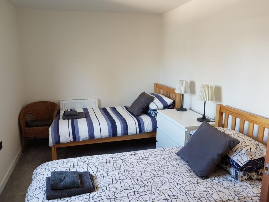 斯托诺韦Stornoway Lido flats的一间卧室配有两张床和椅子