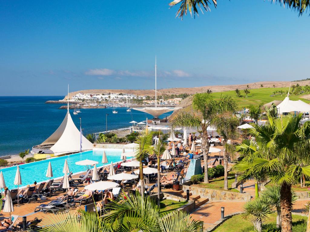 梅罗那瑞斯H10梅洛尼拉斯海滩皇宫酒店的一个带游泳池和海洋的度假胜地