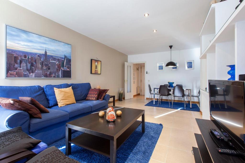 马德里ARGANZUELA的客厅配有蓝色的沙发和桌子