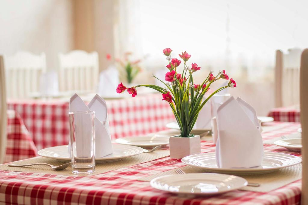 西隆Windermere Inn的一张红白桌子,上面有盘子和花
