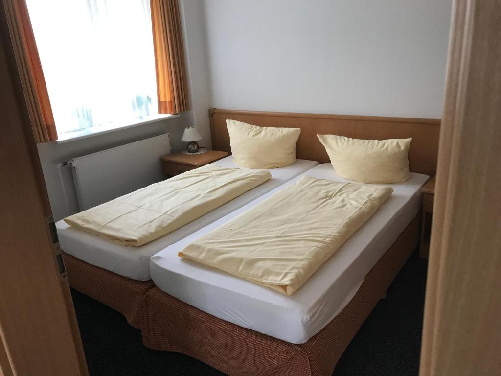 SchönkirchenArp's Gasthof的带窗户的客房内设有两张单人床。