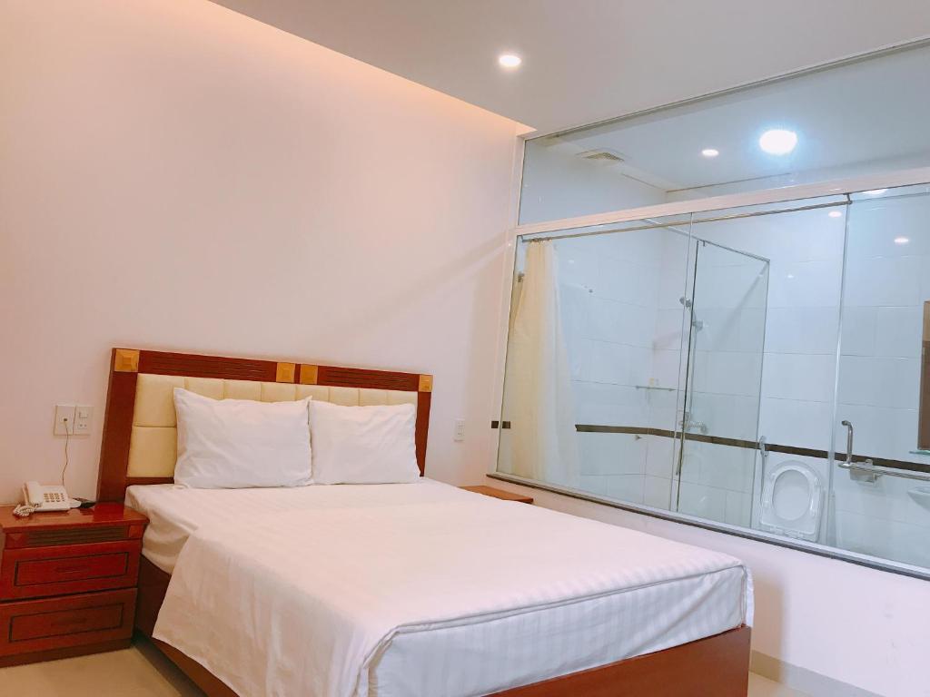 波来古市黄玉酒店的一间卧室设有一张床和一个大窗户