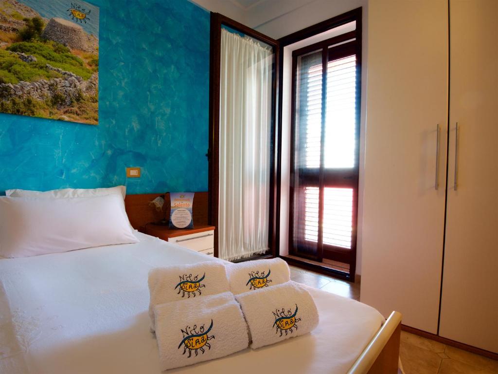 莫尔恰诺迪莱乌卡B&B NiloSira的一间卧室配有带3条毛巾的床