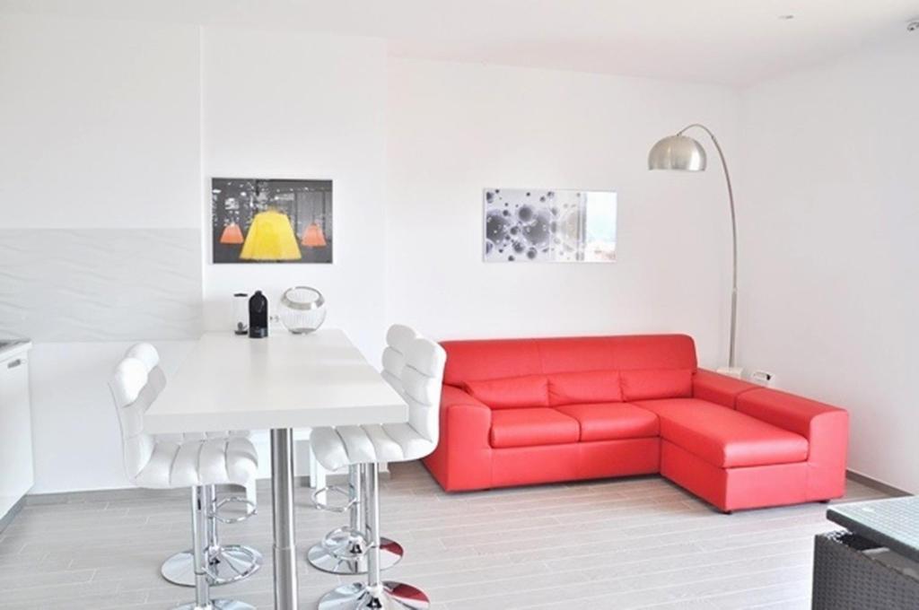 阿尔盖罗三角帆度假酒店的客厅配有红色沙发和白色桌子