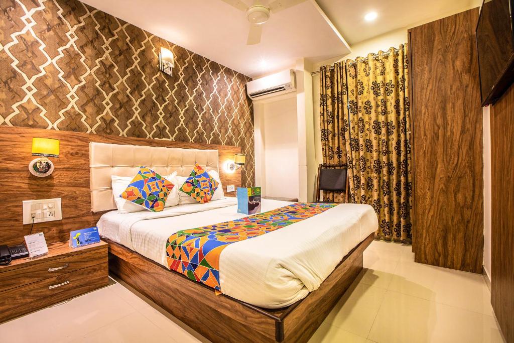 孟买Hygienic Hotel Liberty Plaza的配有一张床和一张书桌的酒店客房