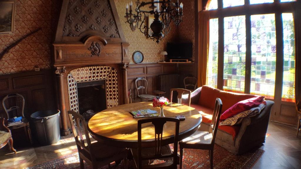 维莱讷-拉瑞埃勒Le Chateau du grand Coudray的一间带桌子和壁炉的用餐室