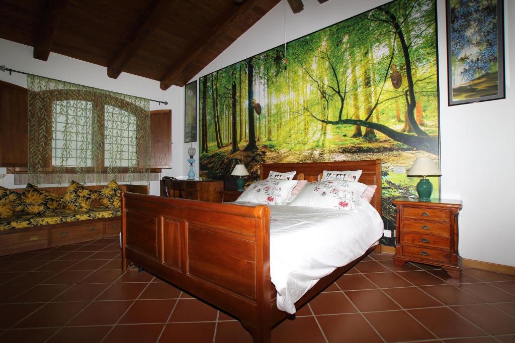 塔尔奎尼亚卡萨莱法尼斯安娜住宿加早餐旅馆的卧室配有一张床,墙上挂有绘画作品