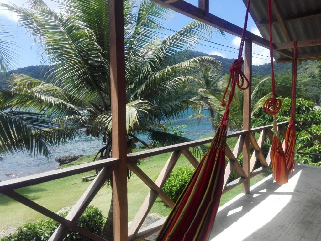 扎普祖罗Hostal El Chileno Sapzurro的配有吊床的门廊享有海景。