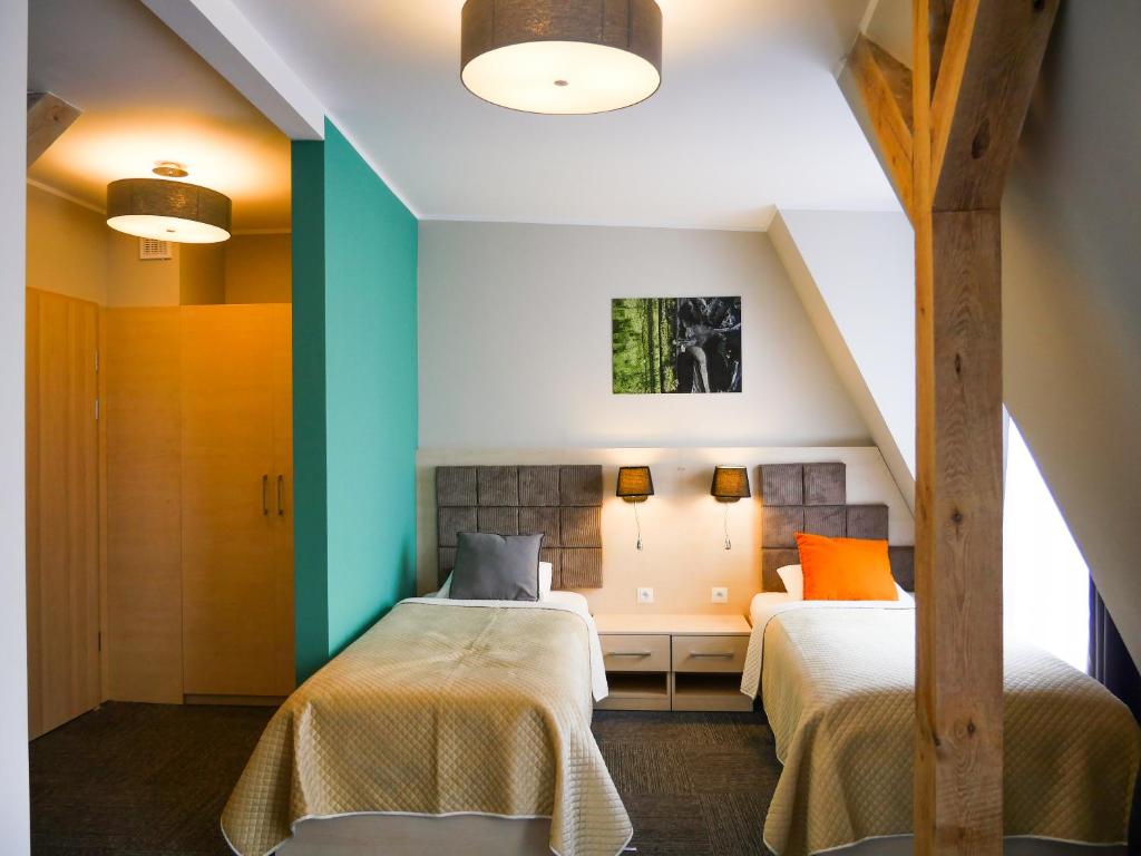 比托姆Aparthotel CENTRUM Gliwicka 18的配有两张床铺的蓝色和绿色墙壁客房