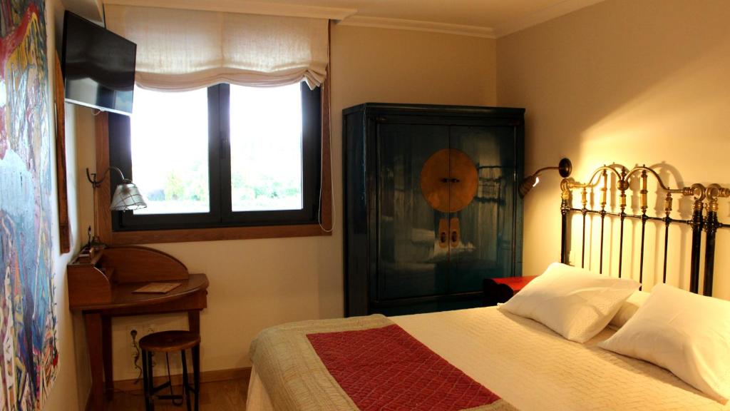 RosalApartamento Spellos的一间卧室设有一张床、一个窗口和一张桌子