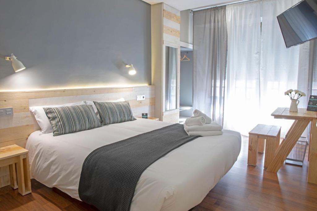 蓬费拉达Hotel Alda Centro Ponferrada的一间卧室设有一张大床和一个窗户。