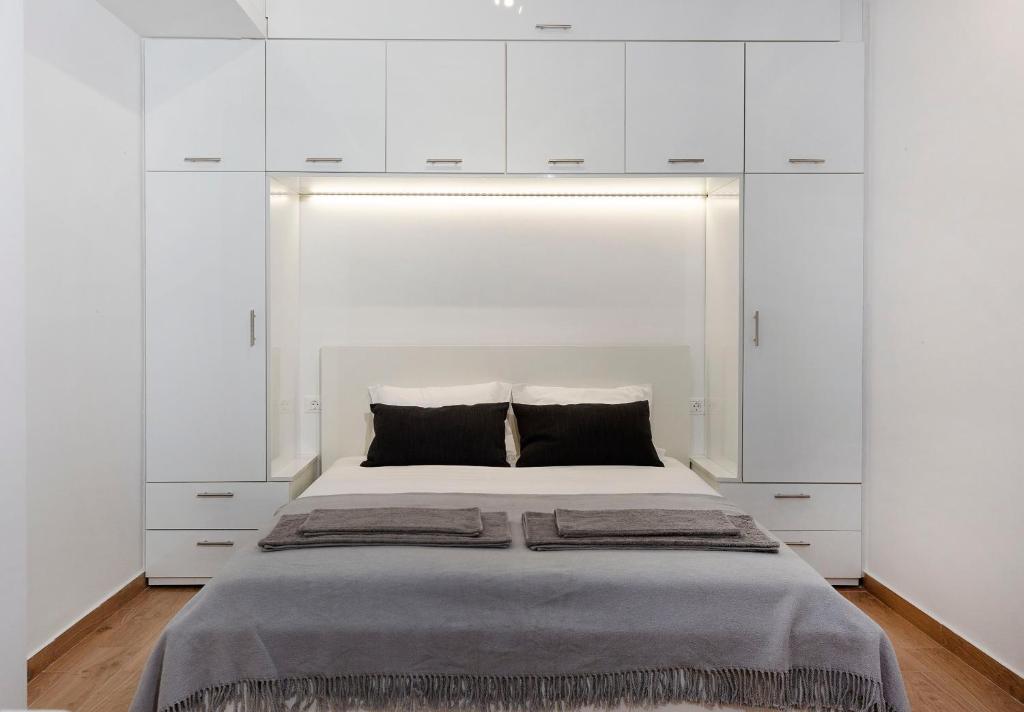 雅典Raise cosy apartment的一间卧室配有一张带白色橱柜的大床