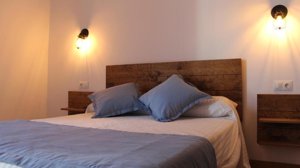 奇克拉纳－德拉弗龙特拉Hospederia 1881的一间卧室配有一张带两个蓝色枕头的床