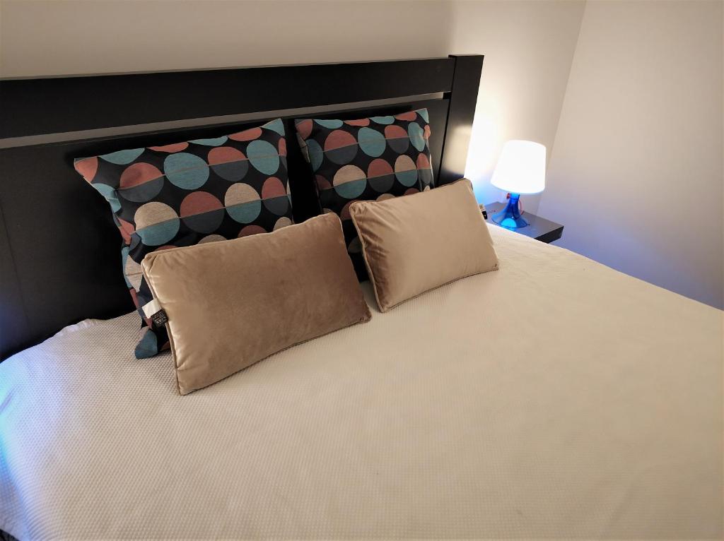 法鲁Sleep & Go Faro Airport Guest House的一间卧室配有一张大床和两个枕头
