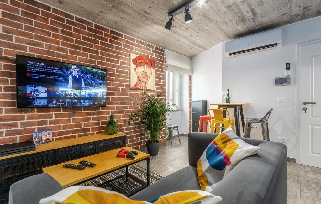 波雷奇Orion apartment的一间设有砖墙和电视的客厅