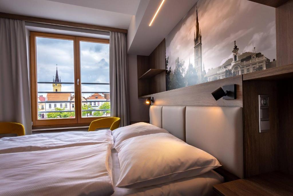 恰斯拉夫Hotel Grand的一间卧室设有一张大床和一个窗户。