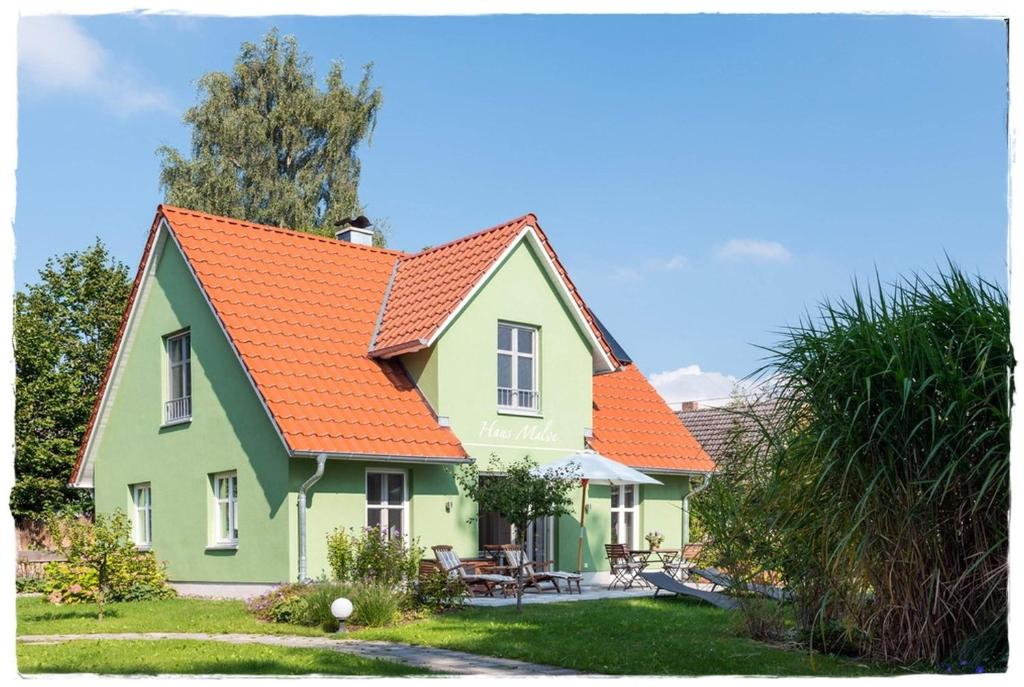朗克维茨Ferienhaus Malve in Liepe的橙色和绿色的房子,有橙色的屋顶