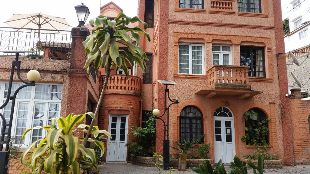 塔那那利佛Relais De La Haute Ville Tana的前面有棕榈树的砖房